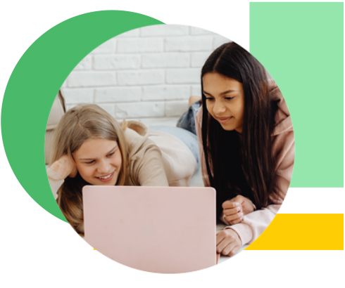 two young girls looking at a laptop