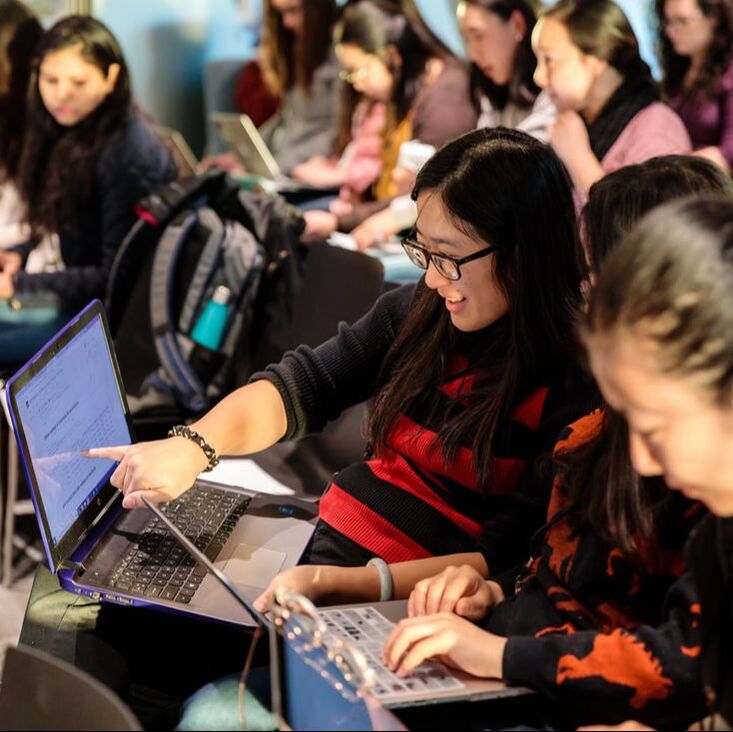 Women collaborating with their laptops open