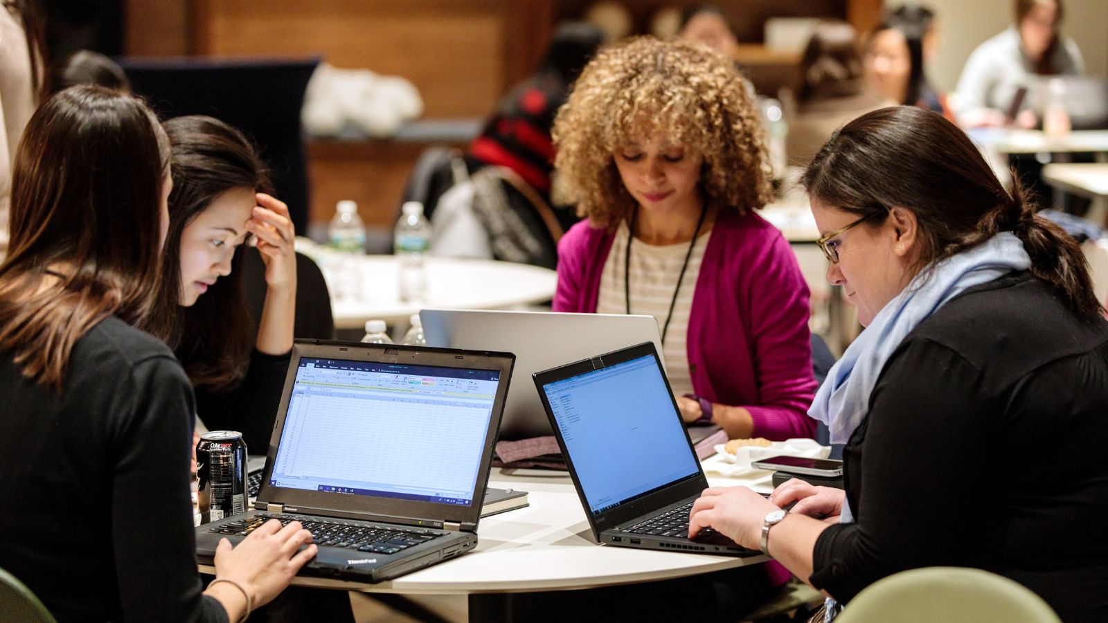 Women working together with laptops open